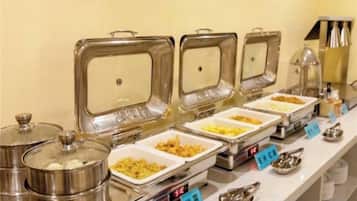 A buffet setup with multiple food containers and serving utensils.