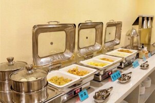 Un montaje tipo bufé con varios recipientes de comida y utensilios.
