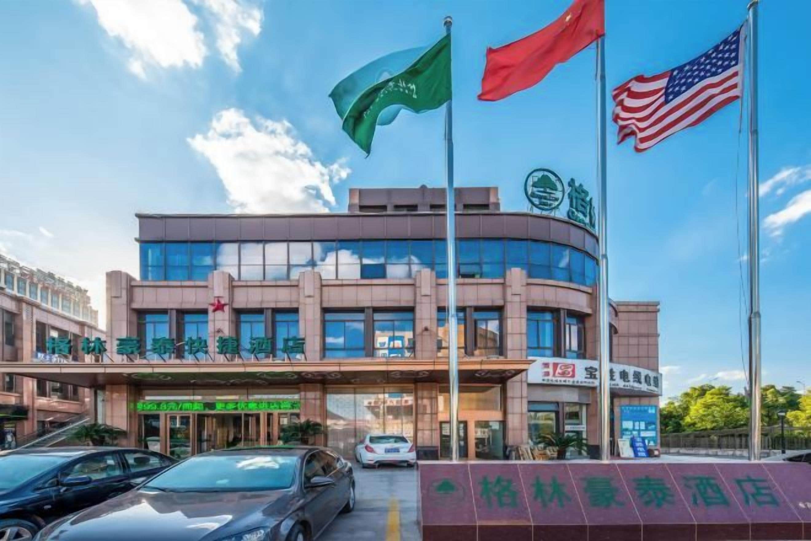 Un hotel con una fachada moderna, varias banderas y un cielo despejado.