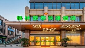 A hotel with a modern facade, a star logo, and illuminated signage. - GreenTree Hotel (Nantong University International Exhibition Center) (Nantong)
