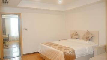 Un dormitorio con una cama, una mesita de noche y una puerta que da a otra habitación.