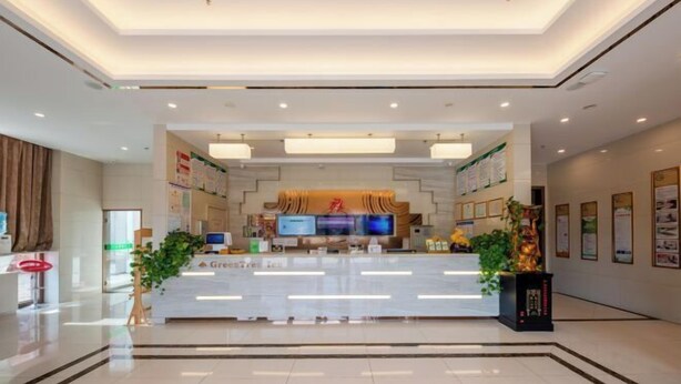 A modern hotel reception area with a central desk, digital screens, and a clean, well-lit interior. - GreenTree Hotel (Nantong University International Exhibition Center) (Nantong)