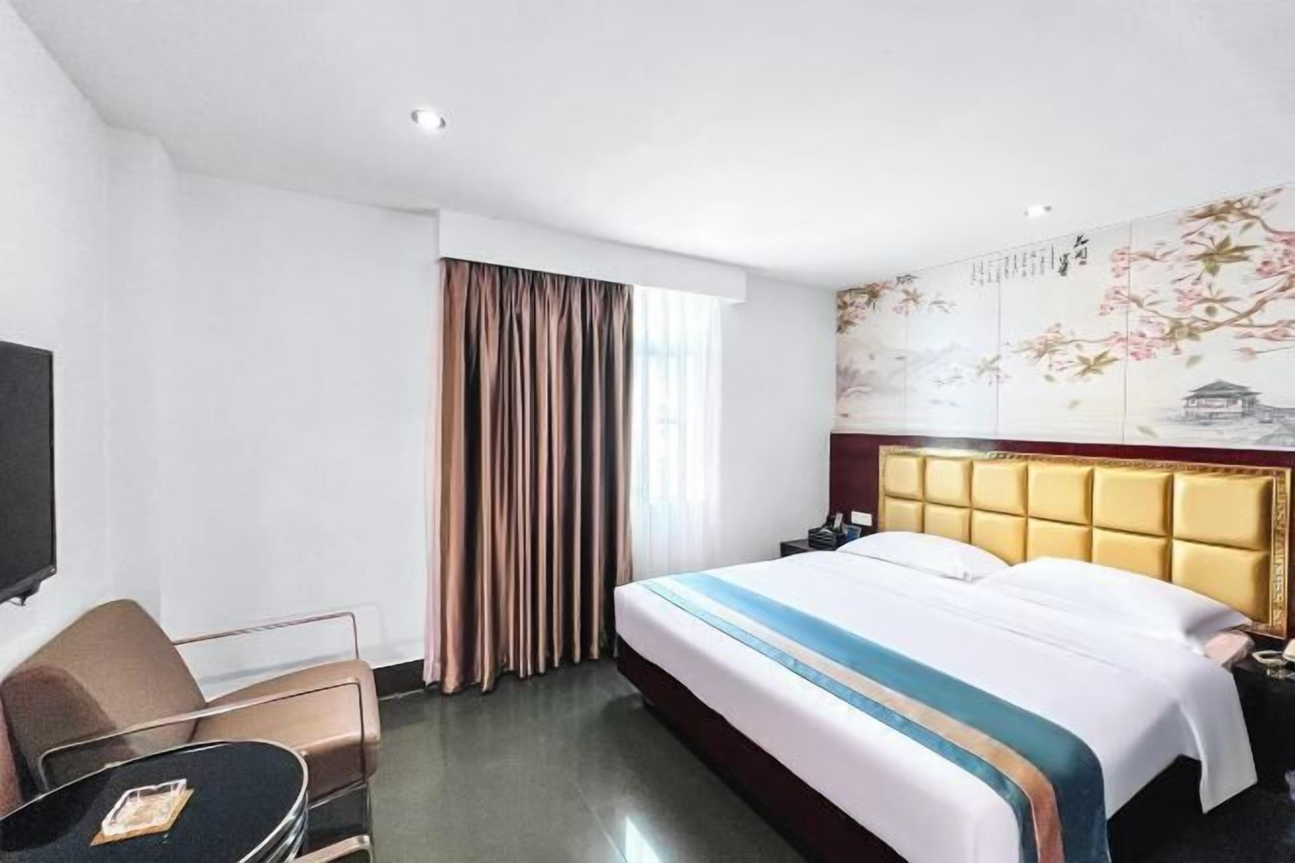 Une chambre d’hôtel avec un lit, une télévision, un bureau et une chaise.