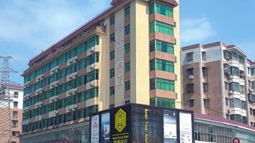 Un hotel de varios pisos con un cartel llamativo que anuncia una cadena hotelera.