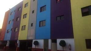 A multi-story building with a flat facade, featuring a series of rectangular windows and a fire extinguisher mounted on the exterior wall. - Hotel Nayarit - Solo Adultos (Mexico City)