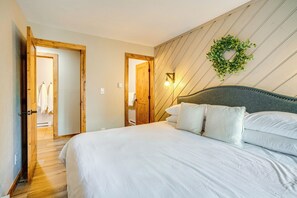 Ein Schlafzimmer mit einem großen Bett, Holztüren und einer Wandleuchte.