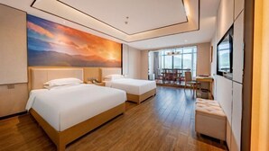Une chambre d’hôtel avec deux lits, un coin repas et un téléviseur.