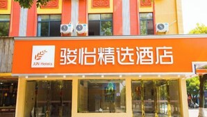 Un hotel con un cartel naranja llamativo que muestra el nombre 'JUN Hotels'.