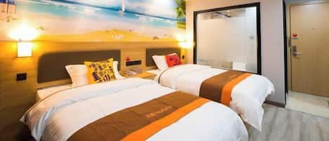 A hotel room with two beds, a beach mural on the wall, and a door to the right.