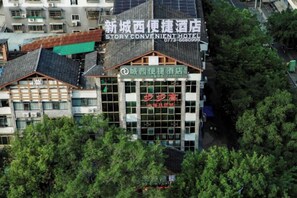 Un hotel de estilo arquitectónico tradicional, con un letrero llamativo y una fachada de vidrio moderna.