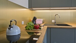 A modern kitchen with a kettle, a pink appliance, and a sink. - P&O Apartments Gdańska (Warsaw)