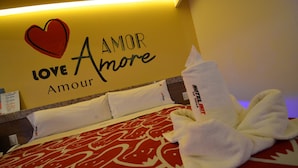A hotel room with a bed, pillows, and a wall sign that reads "LOVE AMOR Amour". - Hotel La Villa - Solo Adultos (Mexico City)
