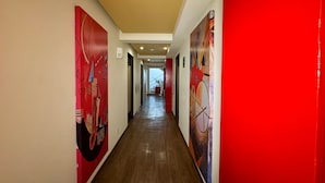 A hallway with red walls and wooden flooring, leading to a staircase. - Hotel La Villa - Solo Adultos (Mexico City)