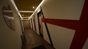 A hallway with doors, a trash can, and a black mat on the floor. - Hotel La Villa - Solo Adultos (Mexico City)