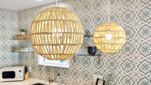 A kitchen with two spherical woven light fixtures, patterned wallpaper, and a microwave on the counter. - The Charleston Suites: The Victoria Suite - 3bd/2ba ample outdoor space (Charleston)