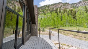 A balcony with a view of a forested mountain range.