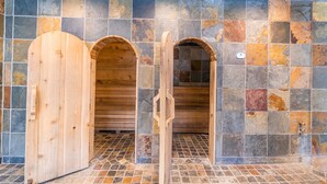 A sauna with wooden doors and a tiled wall.