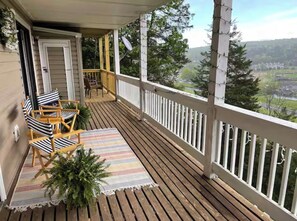A wooden deck with a railing, a door, and two striped chairs. - Cliff’s End • Ski & Golf Views • Fire Pit • Game Room (Basye)