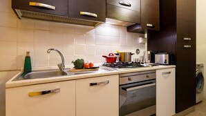 A modern kitchen with a stainless steel sink, a gas stove, a microwave, and a built-in oven. - Signoria - Flo Apartments (Firenze)