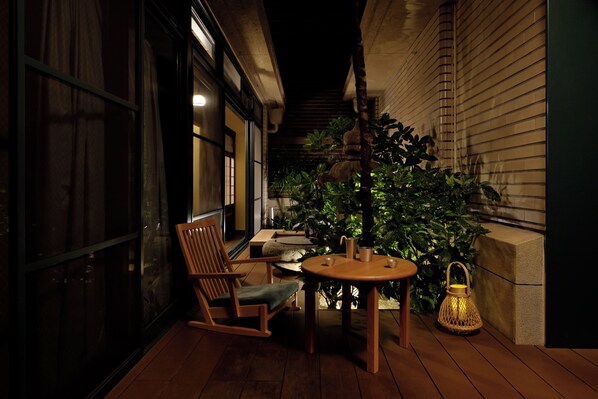 A wooden deck with a table and chairs, a lantern, and a potted plant. - Marufukuro (Kyoto)