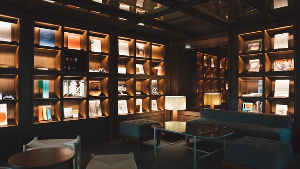 A cozy reading area with bookshelves, a sofa, and a coffee table. - Marufukuro (Kyoto)