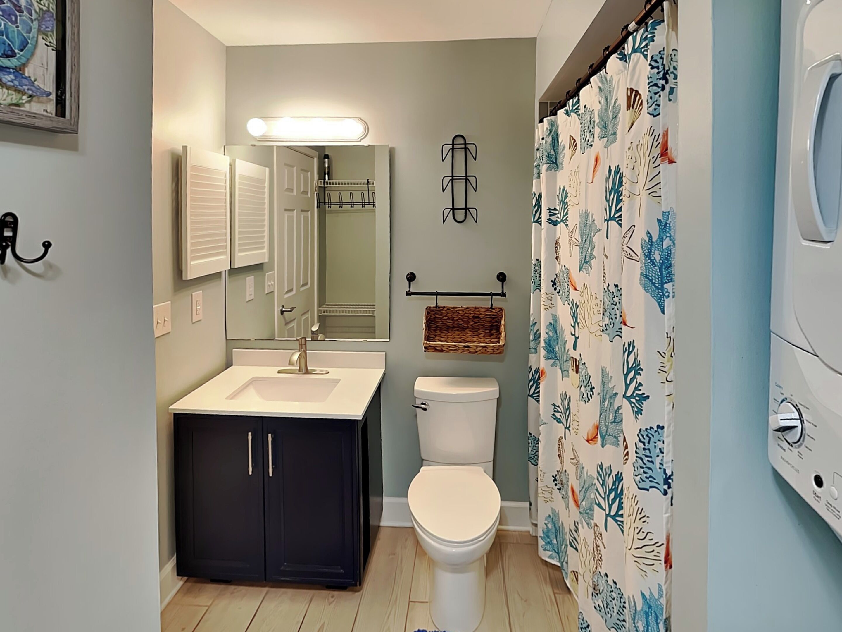 A bathroom with a sink, toilet, and shower curtain.