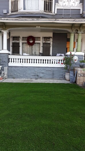 A building with a balcony, a wreath, and a green lawn. - Historic Alvarado Terrace (Los Angeles)