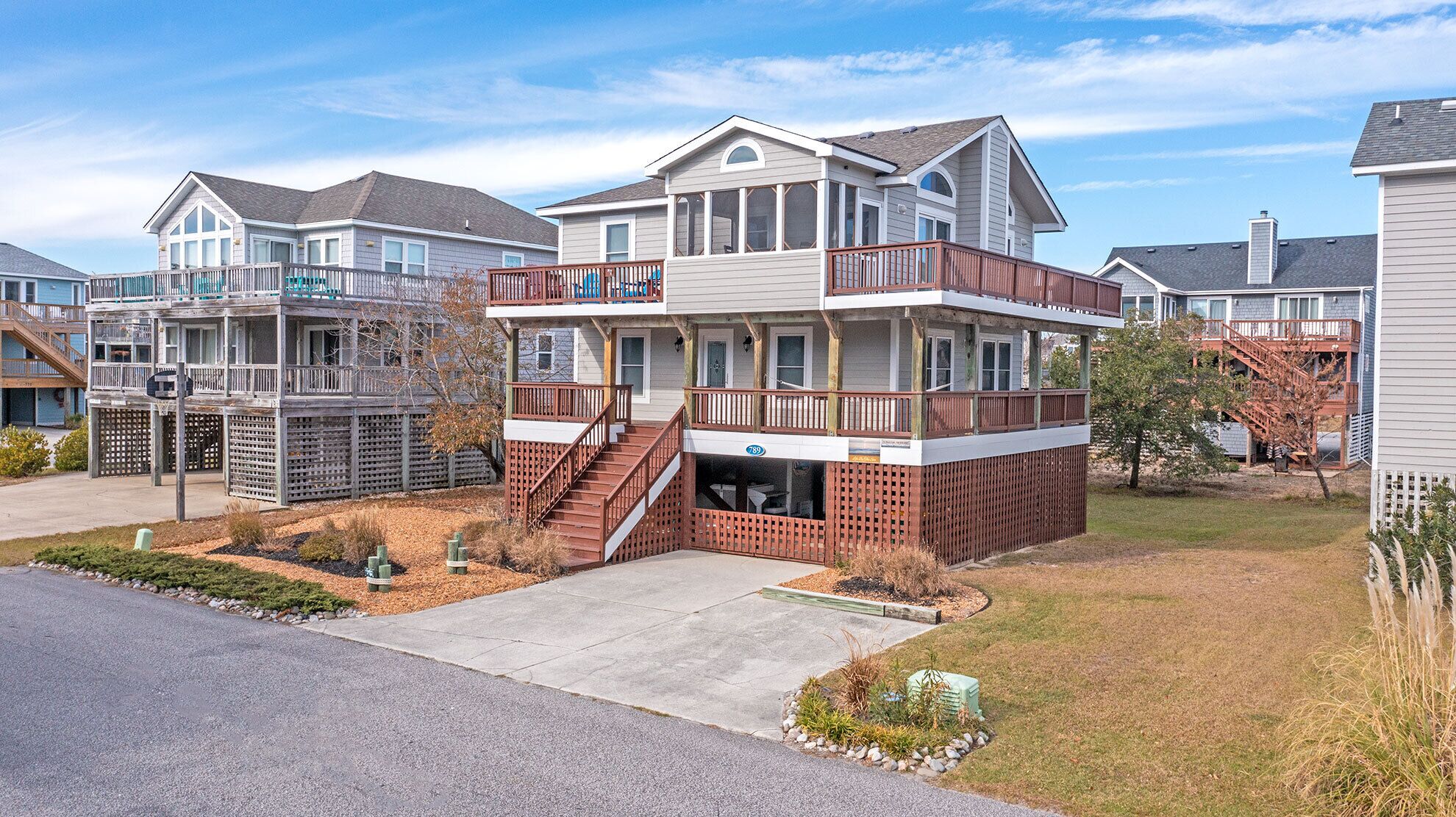 A two-story residential building with a balcony and a covered front porch.