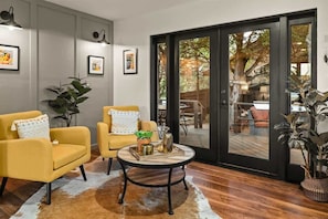 A modern interior with two yellow armchairs, a round coffee table, and a glass door leading outside. - Beautifully Decorated, Private Hot Tub! Pony Soldi (Sedona)