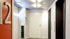 A hallway with a patterned carpet, a white door labeled "Private," and a number "12" on the wall. - APA Hotel Kamata Ekimae (Tokyo)