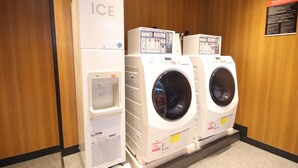 A laundry facility with an ice dispenser, two washing machines, and a control panel. - APA Hotel Kamata Ekimae (Tokyo)