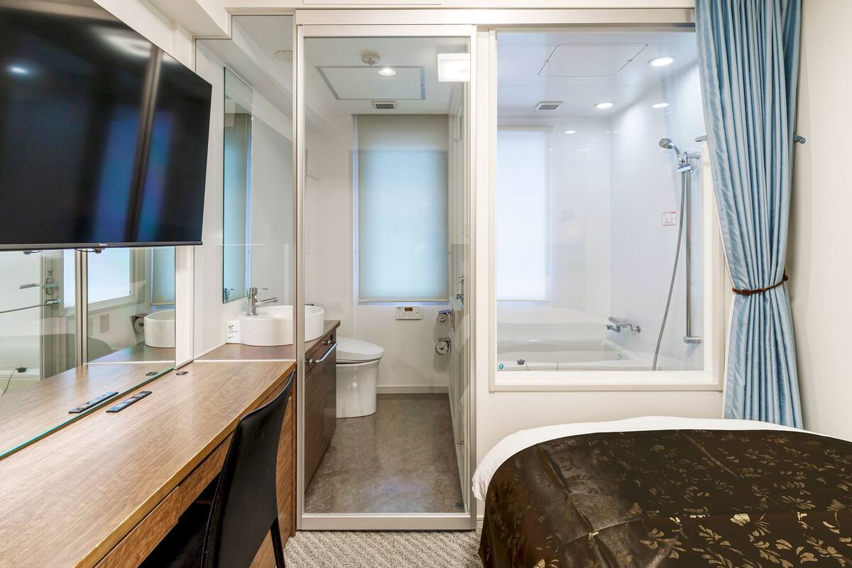 A modern bathroom with a shower, toilet, and sink.