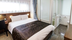 A hotel room with a bed, a desk, a telephone, a window with curtains, and a sliding door leading to a bathroom. - APA Hotel Kamata Ekimae (Tokyo)