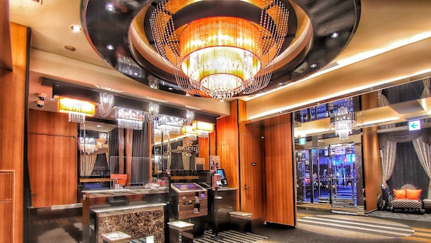 A luxurious lobby with a grand chandelier, a reception desk, and a bar area. - APA Hotel Kamata Ekimae (Tokyo)