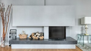 A modern living room with a fireplace, a glass coffee table, and a lamp. - Spacious 2BR + Office near Stephansplatz & Kohlmarkt, by Blueground (Vienna)