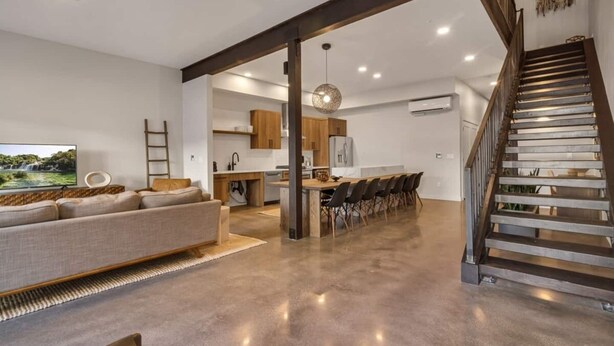 A spacious living area with a sofa, a dining table with chairs, a kitchen area, and a staircase. - Silo at Hara Homes Luxury Stay (Leavenworth)