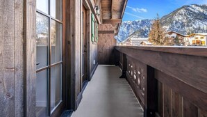 A wooden balcony with a view of snow-covered mountains. - Silo at Hara Homes Luxury Stay (Leavenworth)