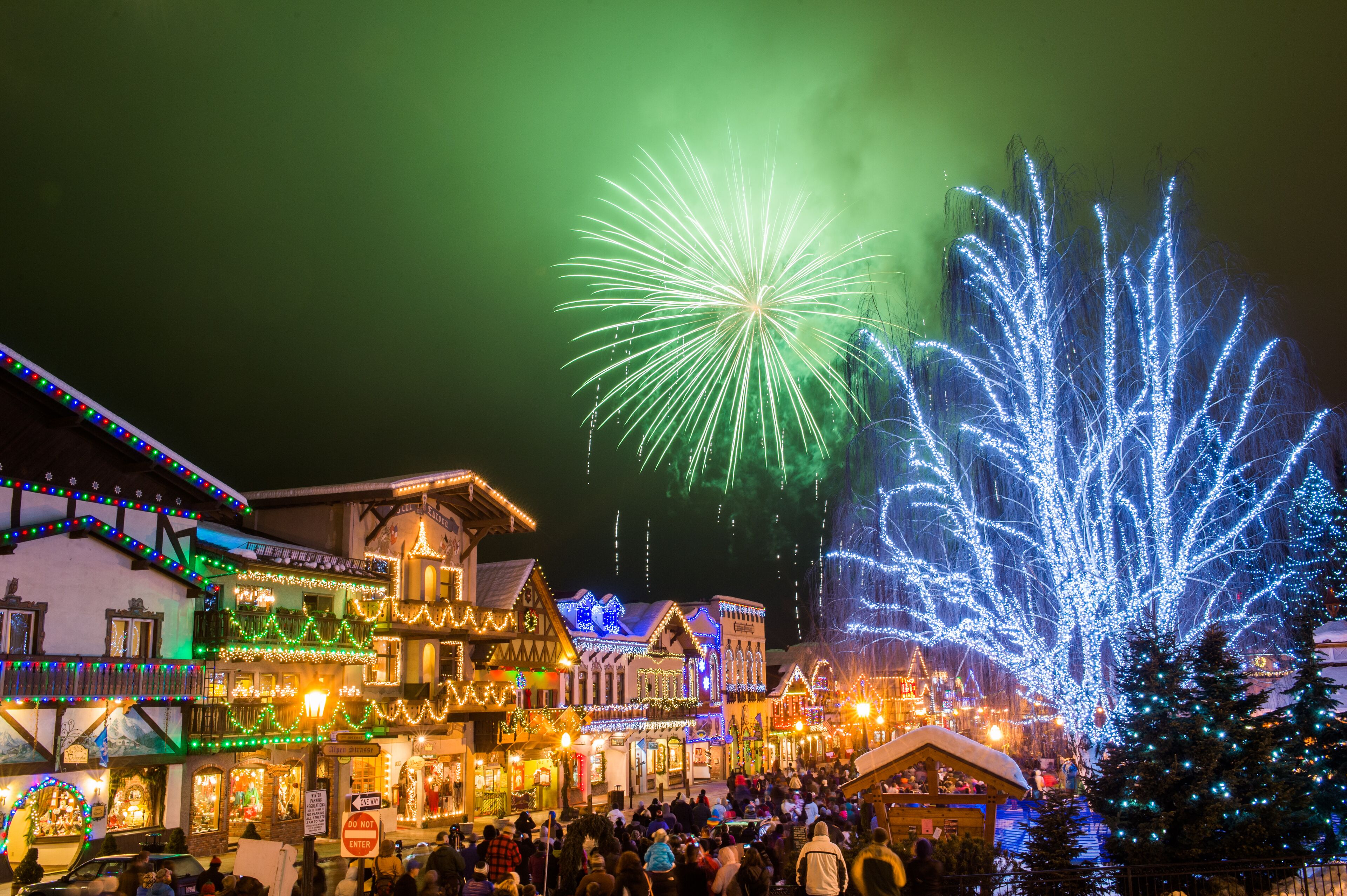 A historic town square with traditional buildings, a Christmas tree, and a crowd of people.