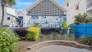 Un bâtiment orné d’une fresque murale intitulée « SIÈGE DE PALM » et d’une clôture bleue.
