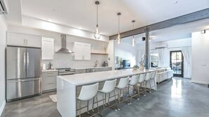 A modern kitchen with a central island, stainless steel appliances, and pendant lighting.