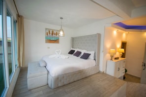Un dormitorio con una cama grande, una mesita de noche con lámparas y un cuadro en la pared.