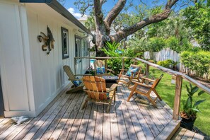 Enjoy outdoor dining or relaxation on this deck surrounded by lush greenery.
