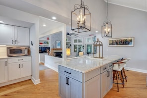 Enjoy cooking in this well-equipped kitchen with a central island, stainless steel sink, and microwave.