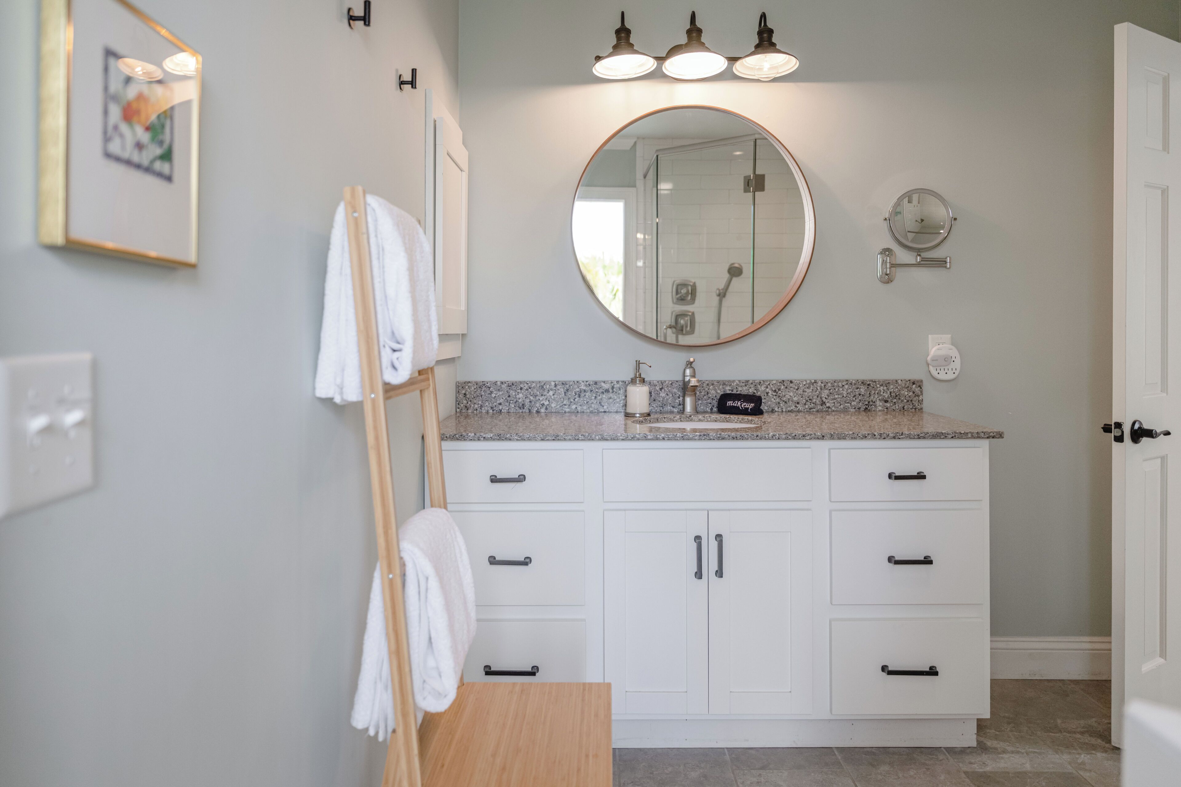 Une salle de bain équipée d’un lavabo, d’un miroir, d’un porte-serviettes et d’un meuble de rangement.