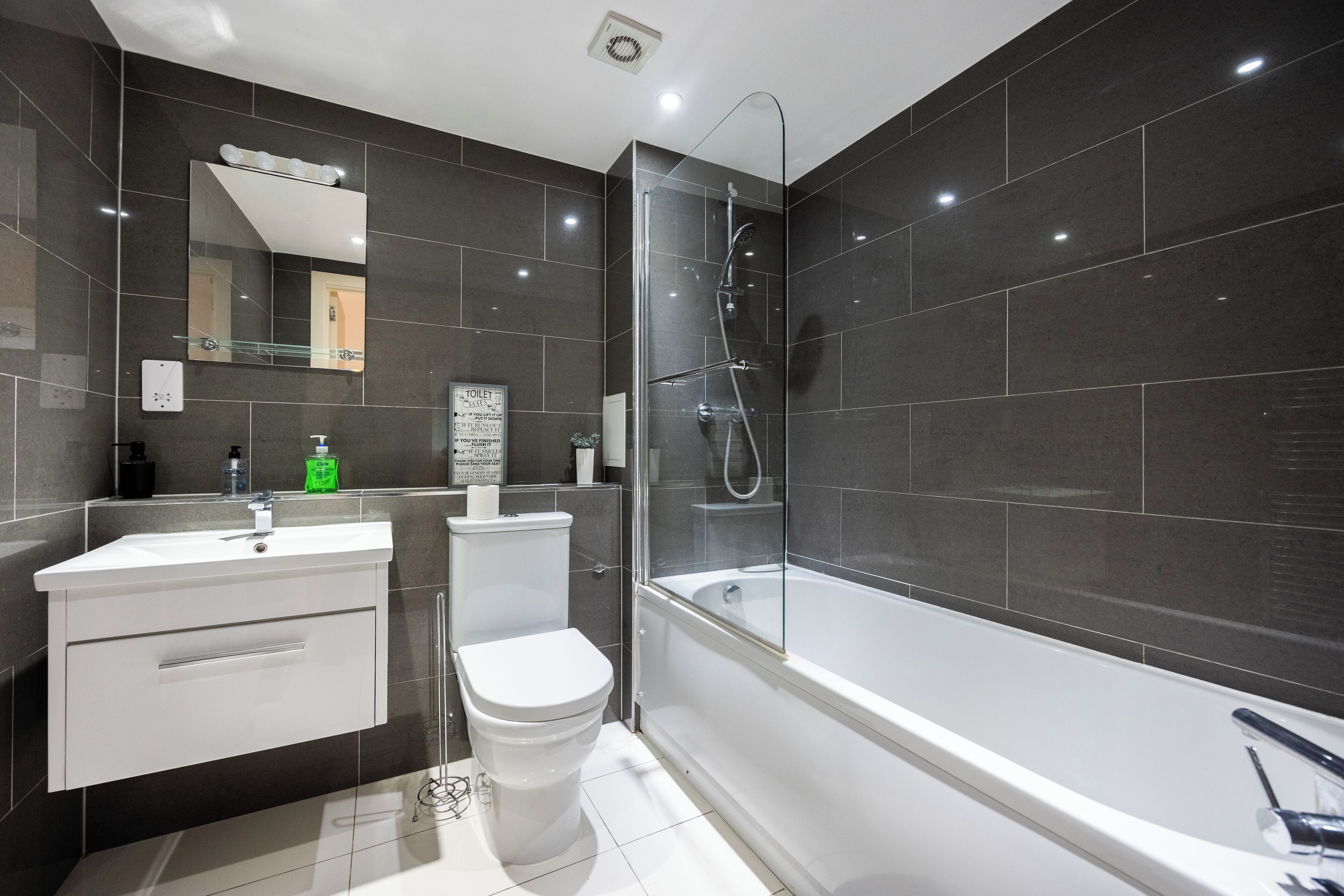 A modern bathroom with a toilet, sink, and bathtub.
