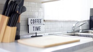 A kitchen counter with a sign that reads "COFFEE TIME" and a cutting board.