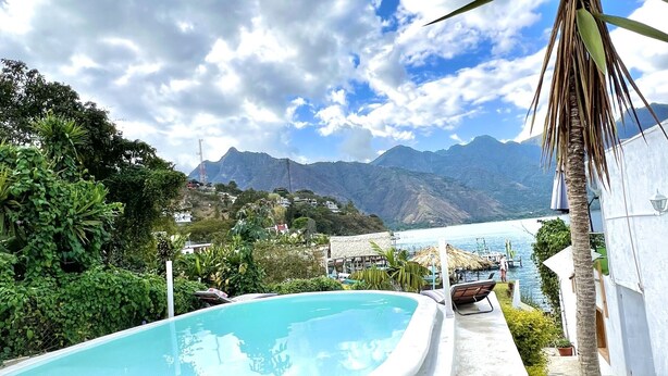 A swimming pool with a view of mountains and a body of water.