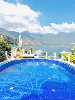 A swimming pool with a view of mountains and a body of water.