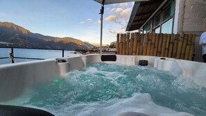 A hot tub with a view of mountains and a body of water. - TIBERIAS by luxury atitlan (San pedro la Laguna solola)
