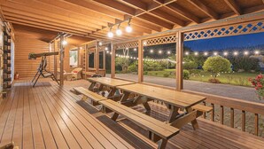 A wooden deck with picnic tables and a telescope. - Gyeongju Cabinhouse (Gyeongju)